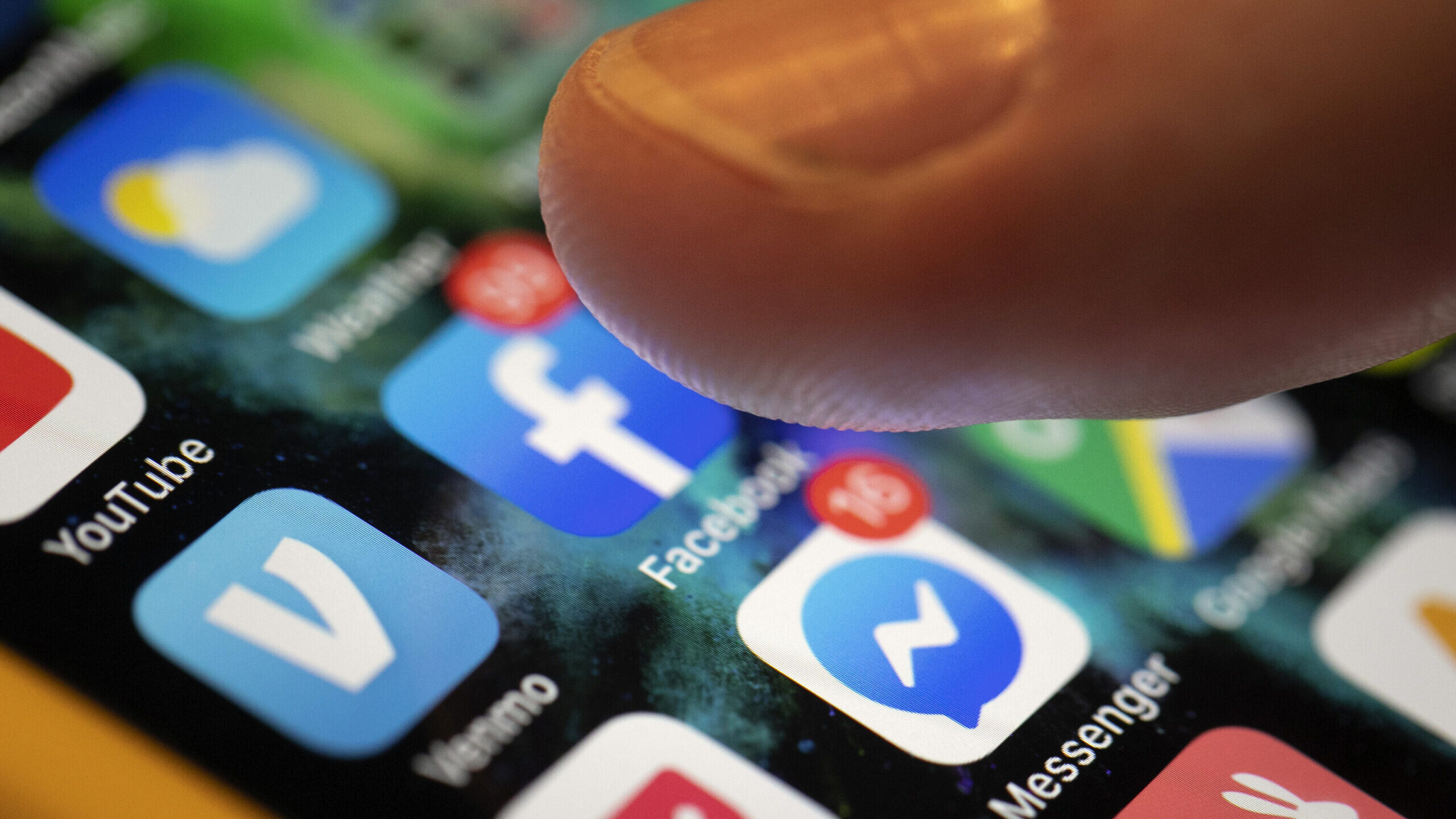 someone taps on facebook icon, utah lawmakers working to protect kids from social media...